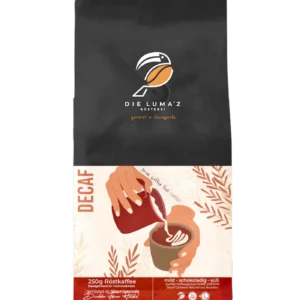 DECAF Kaffee: Schwarze 250-g-Kaffeepackung LUMAZ „DECAF“ mit Illustration beim Eingießen von Latte Art; mild, schokoladig, süß; entkoffeinierter Kaffee aus Brasilien.