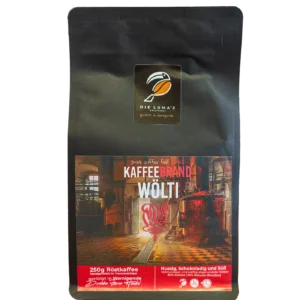 KaffeeBrand Wölti. Schwarze 250-g-Kaffeepackung LUMAZ „KaffeeBrand Wölti“ mit Motiv einer Kupfer-Brennerei; nussig, schokoladig, süß; 80 % Arabica, 20 % Robusta.
