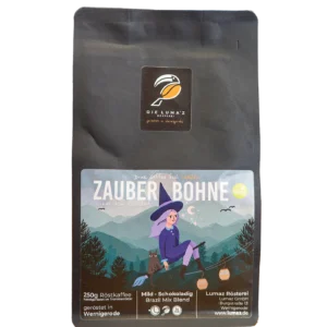 Zauberbohne Kaffee. Schwarze 250-g-Kaffeepackung LUMAZ „Zauberbohne“ mit Hexen-Illustration in Berglandschaft; mild, schokoladig; Brazil Mix Blend, geröstet in Wernigerode.
